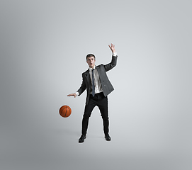 Image showing Caucasian man in office clothes training isolated on grey studio background