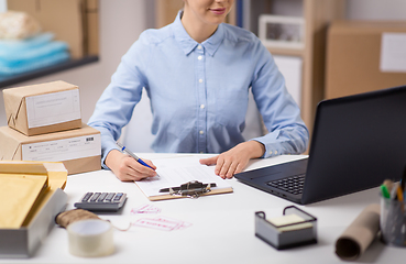 Image showing woman with laptop and clipboard at post office