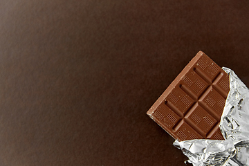 Image showing chocolate bar in foil wrapper on brown background