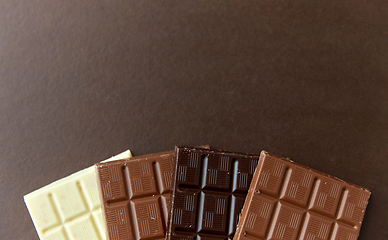 Image showing different kinds of chocolate on brown background