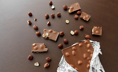 Image showing milk chocolate bar with hazelnuts in foil wrapper