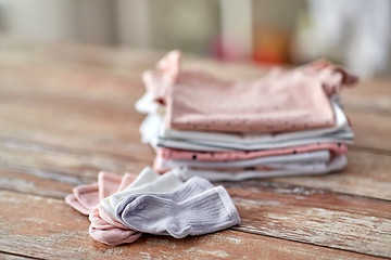 Image showing baby clothes on wooden table at home