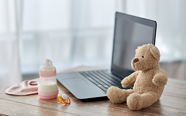 Image showing baby milk formula, laptop, soother and teddy bear