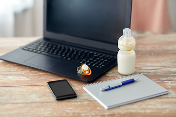 Image showing baby milk formula, laptop and soother on table