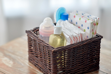 Image showing baby things in basket on wooden table at home