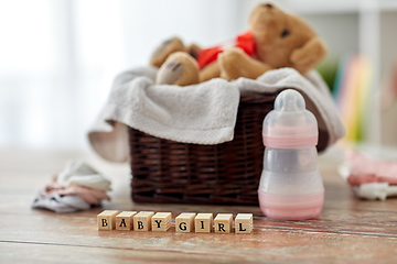 Image showing teddy bear toy in basket with baby things on table