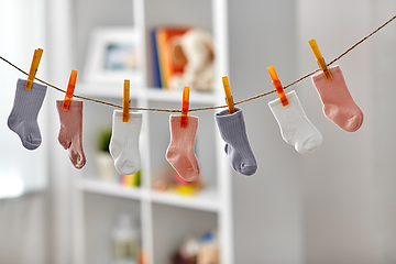 Image showing little socks for baby girl on clothesline at home