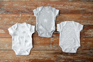 Image showing baby clothes set of bodysuits on wooden table