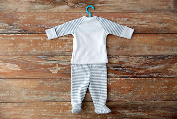 Image showing baby clothes set with hanger on wooden table