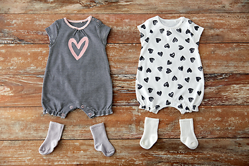 Image showing baby bodysuits and socks on wooden table