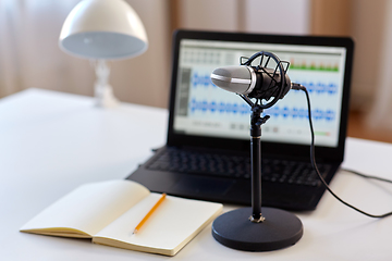 Image showing microphone, laptop and notebook on table