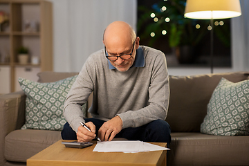 Image showing senior man with bills and calculator at home