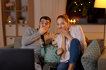 Image showing scared family watching tv at home at night