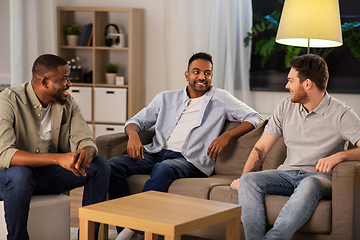 Image showing happy male friends talking at home at night