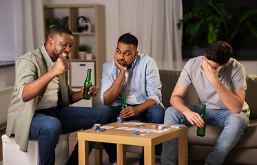 Image showing male friends playing cards at home at night