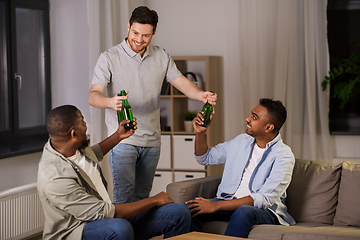 Image showing happy male friends drinking beer at home at night