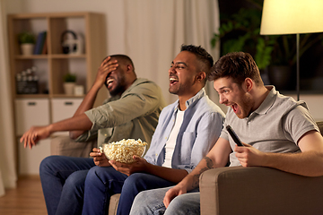 Image showing male friends with popcorn watching tv at home