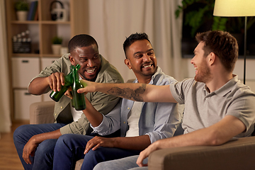 Image showing happy male friends drinking beer at home at night