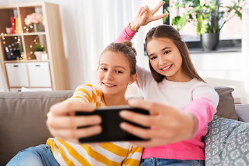 Image showing happy girls taking selfie with smartphone at home