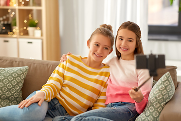 Image showing happy girls taking selfie with smartphone at home