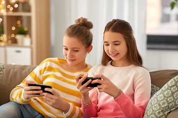 Image showing happy teenage girls with smartphones at home