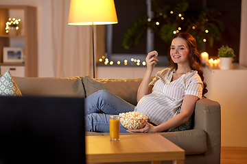 Image showing pregnant woman with popcorn watching tv at home