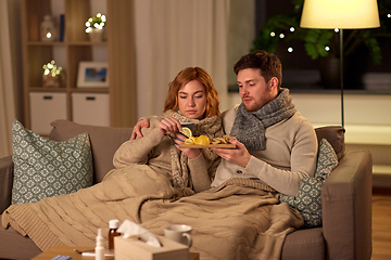 Image showing sick young couple drinking tea with lemon at home