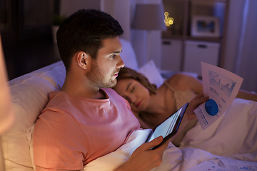 Image showing man with tablet computer working in bed at night