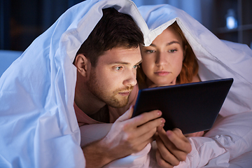 Image showing couple using tablet pc in bed at night