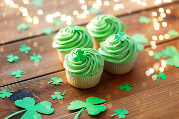 Image showing green cupcakes and shamrock on wooden table