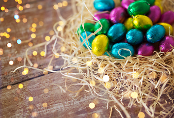 Image showing chocolate eggs in foil wrappers in straw nest