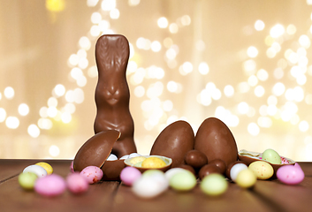 Image showing chocolate eggs, easter bunny over festive lights