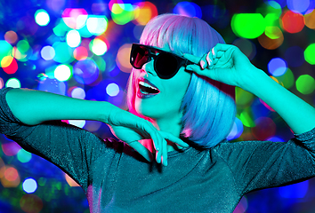 Image showing happy woman in pink wig and sunglasses dancing