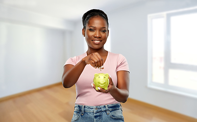 Image showing african american woman with piggy bank at new home