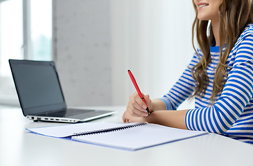 Image showing student girl with exercise book, pen and laptop