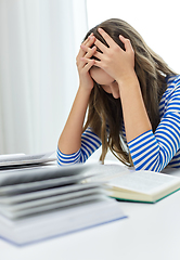 Image showing stressed student girl with books learning at home