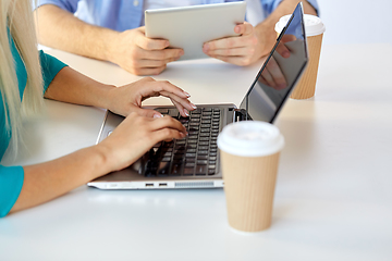 Image showing woman typing on laptop and coffee cups on table