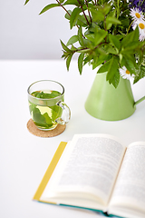 Image showing herbal tea, book and flowers in jug on table