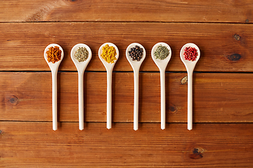 Image showing spoons with different spices on wooden table