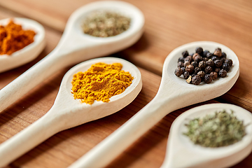 Image showing spoons with different spices on wooden table