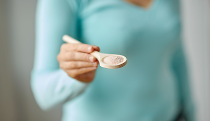 Image showing close up of woman with sea salt on wooden spoon