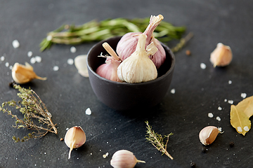 Image showing garlic in bowl and rosemary on stone surface