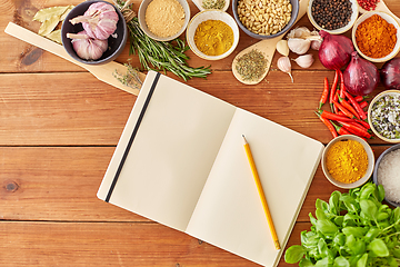 Image showing notebook with pencil among spices on wooden table