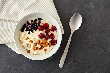 Image showing porridge breakfast with berries, almonds and spoon