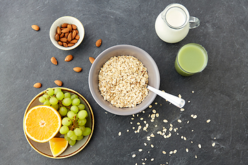 Image showing oatmeal with fruits, almond nuts and jug of milk