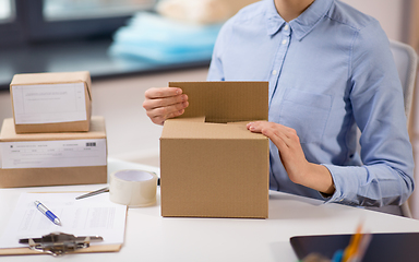 Image showing woman packing parcel box at post office