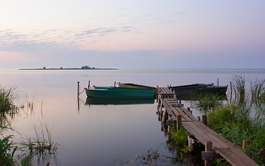 Image showing Wooden Pier with Moored Boats on the Lake During Dawn