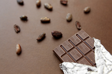 Image showing dark chocolate bar in foil wrapper and cocoa beans