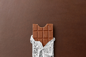 Image showing chocolate bar in foil wrapper on brown background