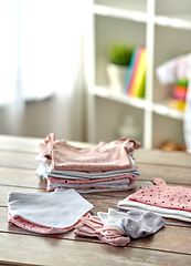 Image showing baby clothes on wooden table at home